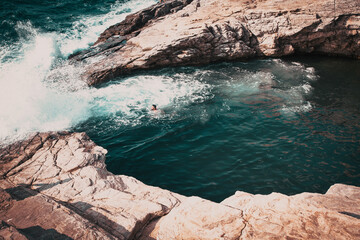 woman swimming in sea cove with turquoise water