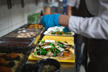 Close-up of cook preparing meal in commercial kitchen.