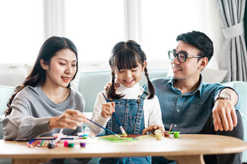 Fototapeta premium picture of family sitting and painting together