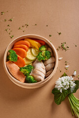 Bowl with salmon and chicken on a brown decorated background