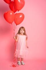 Obraz na płótnie Canvas cute child girl in pink dress with red heart balloons on pink background. Valentine day
