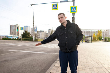 male person catching a taxi car in the city standing near highway