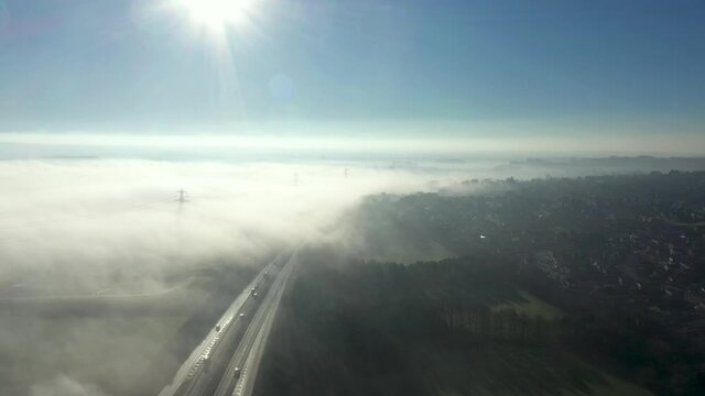 Aerial view of fog in the countryside covering a motorway