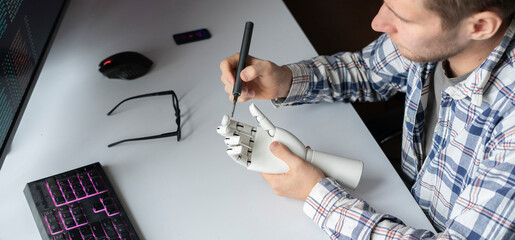 male engineer working on the development of robotic arm or hand, new modern technology concept