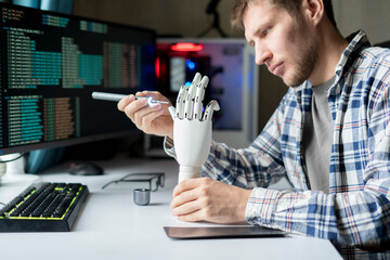 male engineer working on the development of robotic arm or hand, new modern technology concept