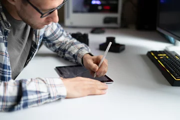 Foto op Plexiglas male graphic designer working using stiylus and tablet in the studio © Mihail