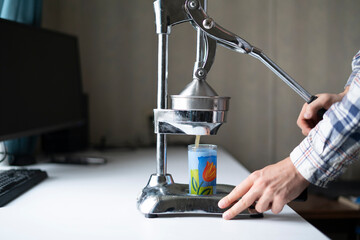 person making orange fresh juice using metal manual press