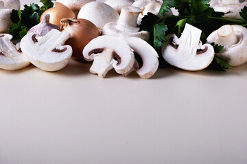Close-up background of whole and sliced champignons with other cooking ingredients. Selective focus. Copy space.