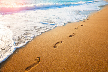 footprints on  tropical beach and beautiful  wave