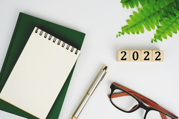 new year plan. 2022 Plans. keyboard, glasses, notebook, and pen, 2022  word is written on woodblock, top view, planning concept, business finance goal setting concept.                         