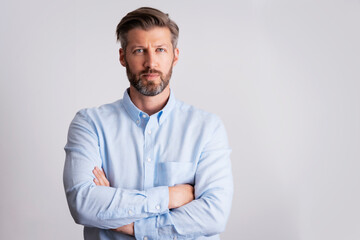 Serious faced man wearing shirt while standing at isolated white background