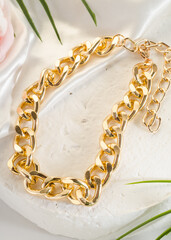 Fashion bijouterie - a large gold chain bracelet on a white stand
