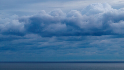 Naklejka na ściany i meble Panoramic view of bright blue sea, blue sky with fluffy white clouds