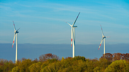 Windmills wind turbines farm power generators. Production of renewable green energy