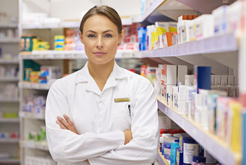 You're in capable hands. Portrait of an attractive young pharmacist standing in an aisle.
