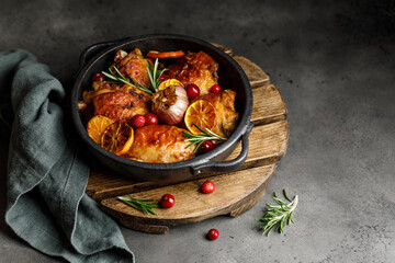 Chicken thighs baked with orange and rosemary in a ceramic dish