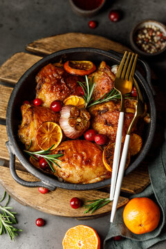 Chicken thighs baked with orange and rosemary in a ceramic dish