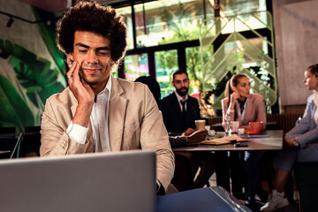 African American businessman working at cafe using laptop.
