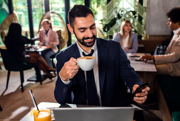 Young businessman working at cafe using laptop.