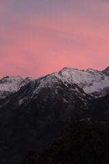 Purple and pink vivid sunset over snow capped alpine mountains (Aosta, Italy)	
