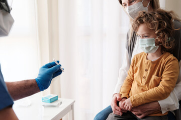 Fototapeta premium A medical staff showing the result of the antigen test to a mother with her young child.