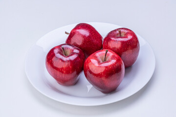 Apples in white plate on white background isolated.