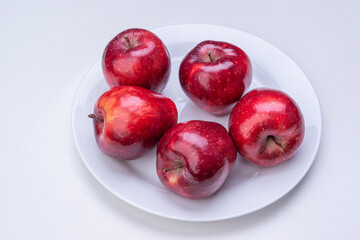 Apples in white plate on white background isolated.