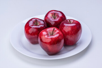 Apples in white plate on white background isolated.
