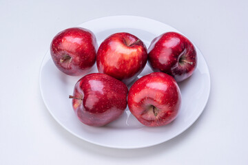 Apples in white plate on white background isolated.
