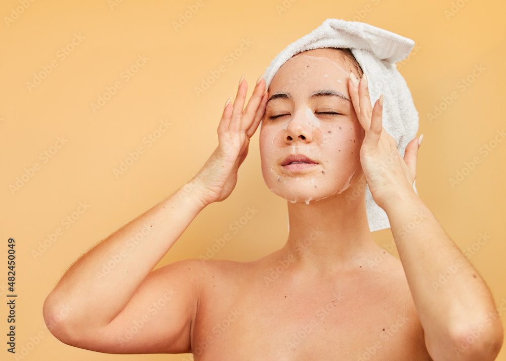 Wall mural Make time to treat yourself. Shot of a young woman applying a face mask during her morning beauty routine against a yellow background.