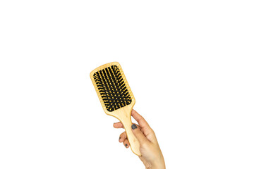 closeup woman hand holding a wooden hair brush isolated on white background 