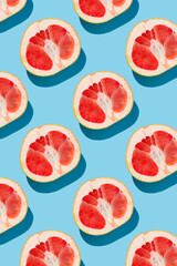 fruit pattern of fresh ripe slice grapefruits on blue background. top view