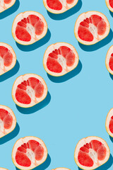 fruit pattern of fresh ripe slice grapefruits on blue background. top view
