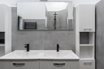 Double sink in bathroom. Ceramic washbasin in wasroom with grey tiles and mirror in stylish interior in hotel.