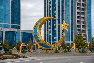 A crescent moon with a star on the background of a modern residential complex Argun City. Chechen...