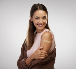 Vaccine shots tequila shots. Shot of a young woman standing alone in the studio after getting vaccinated. © Siphosethu Fanti/peopleimages.com