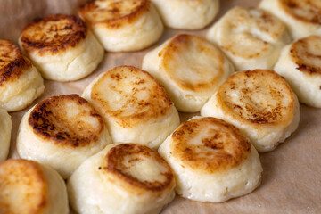 Cheesecakes on a baking sheet, cook in the dining room. Beautiful, rosy and fried.
