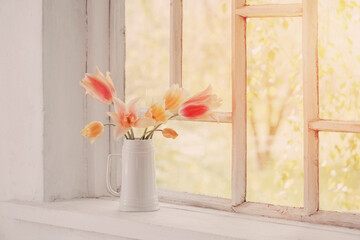 beautiful tulips in vase on white windowsill