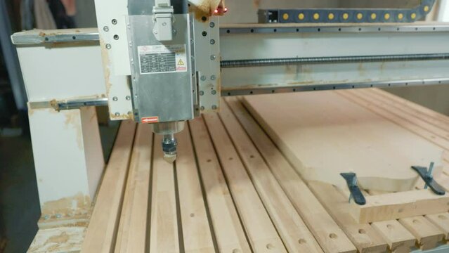 CNC machine cuts a pattern on a piece of wood
