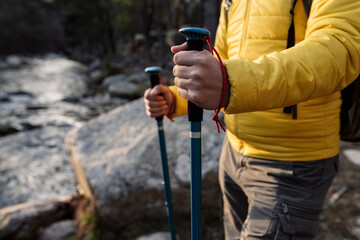 Naklejka premium man trekking in the river forest, at sunset