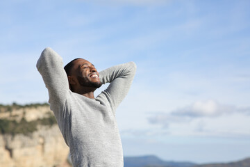 Relaxed man with black skin breathing in the mountain - obrazy, fototapety, plakaty