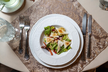 Dietary salad with tomatoes, feta, lettuce, spinach and pine nuts. Top view.