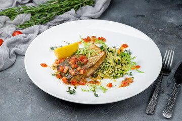 fried halibut with spinach and risotto on grey table