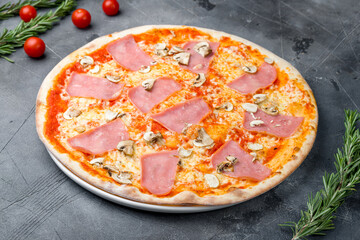 Pizza with ham and mushrooms on grey table