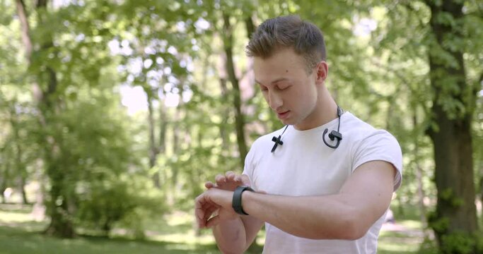 Athletic man using smartwatch in a park