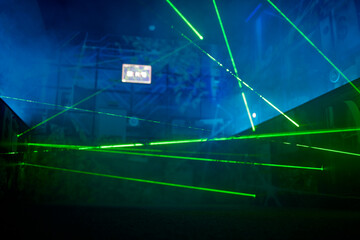 Bright green neon laser lights illuminate the darkness creating lines and triangle shapes in sci-fi...