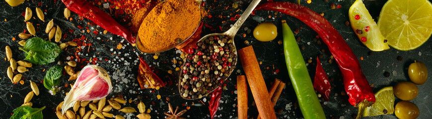 Fototapety  Spices and aromatic herbs on a dark table. Wide photo