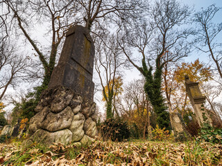 Fototapeta premium Tombstone cemetery tomb stone with autumn color background