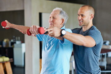 The long road to physical rehabilitation. Shot of a physiotherapist helping a senior man with...