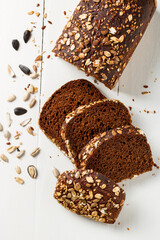 Pieces of cereal bread with sunflower seeds on a white rustic table